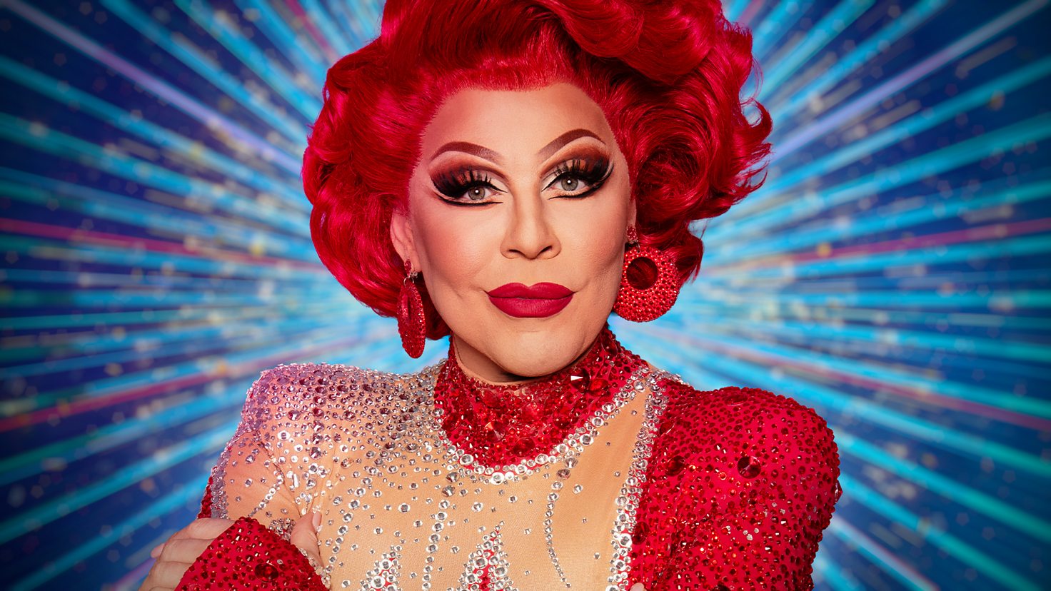 La Voix in signature red wig, lipstick and sequin studded gown, BBC Strictly Come Dancing 2025 press shot