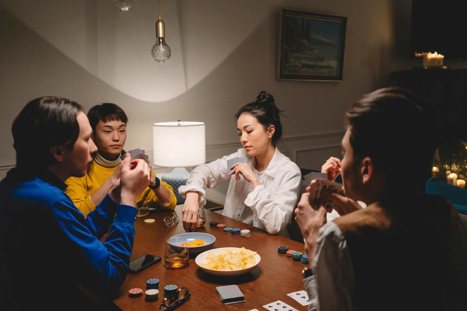 A group of people sitting at a table playing cards
