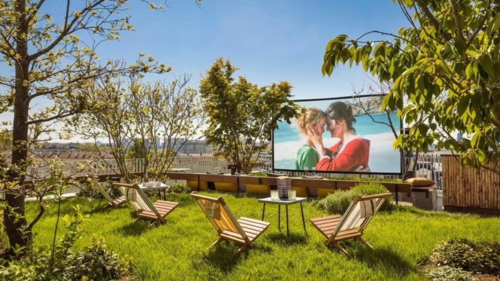 the rooftop of the hotel, showing a grassy lawn and deck chairs