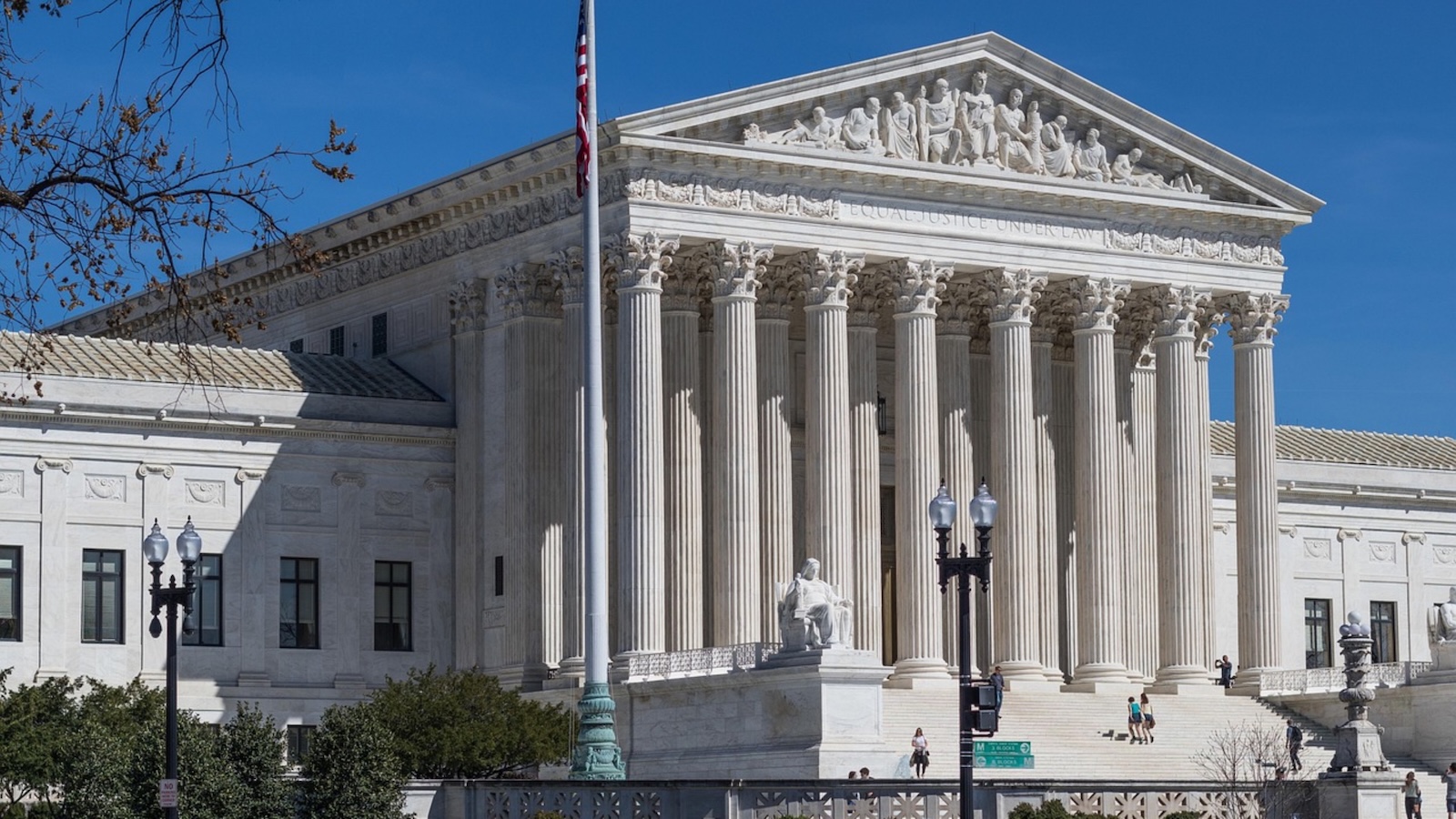 US Supreme Court with flag pole and greenery