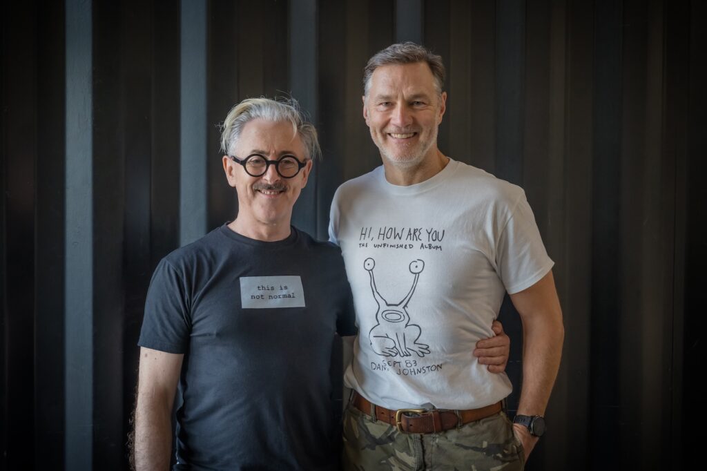 Alan Cumming with his hand around David Morrissey 