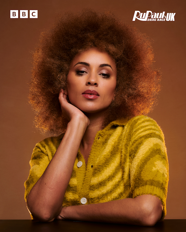 Michelle de Swarte resting her head on her chin wearing a yellow striped top