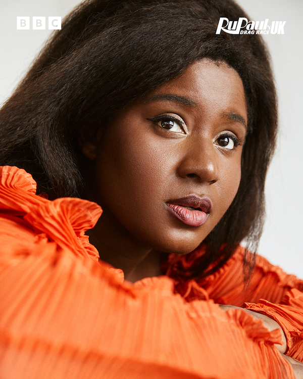 Susan Wokoma in an orange top