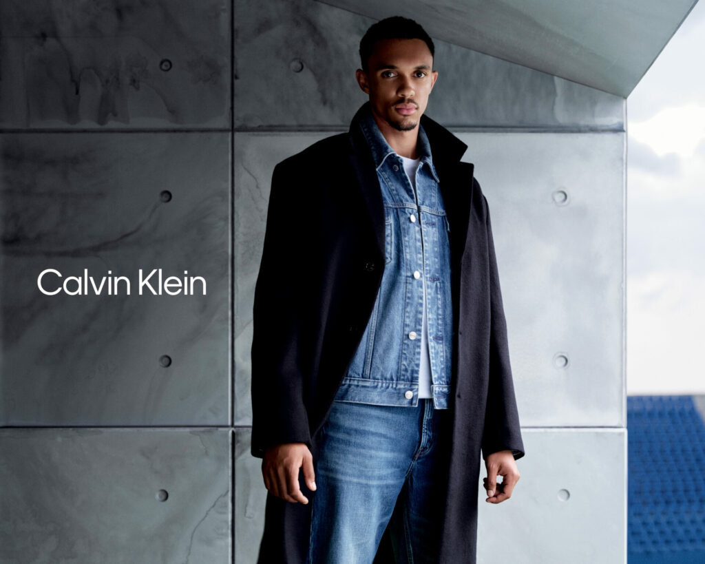 Footballer Trent Alexander-Arnold stars in the Calvin Klein Autumn 2025 campaign wearing a black overcoat layered over matching denim jacket and jeans.
