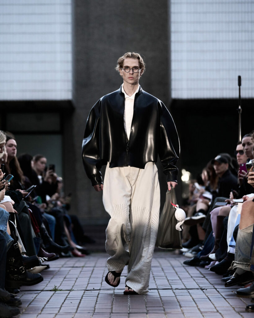 A model wears a latex bomber jacket from the HARRI Spring/Summer 2026 collection.