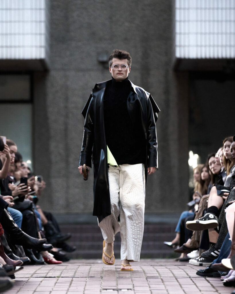 A model wears a latex coat from the HARRI Spring/Summer 2026 collection