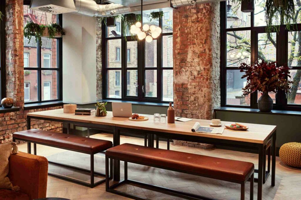 Interior shot of the LEVEN hotel's breakfast area showing exposed brick walls and a long dining table