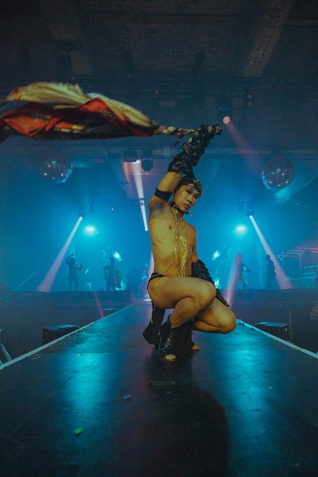 topless man voguing with a flag