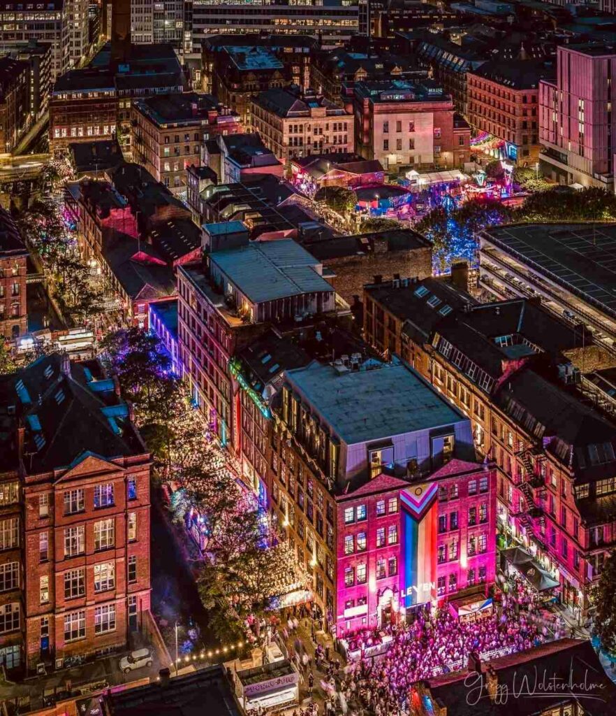 Drone shot above Canal Street showing throngs of people in the streets and neon lights
