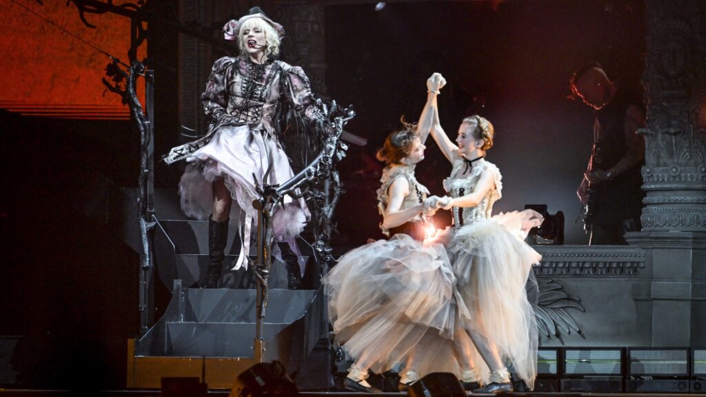 Lady Gaga at The Mayhem Ball at London's O2 Arena in London last night, with two dancers standing beside her (Image: Samir Hussein/Getty Images for Live Nation)