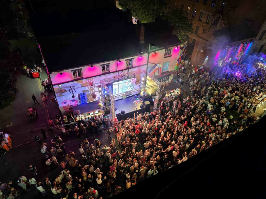 Aerial view of a crowd partying on Canal Street in front of a performance stage