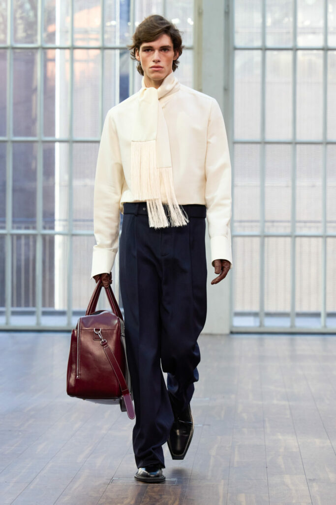 A model wears a white shirt and tassel scarf from the Mithridate Spring/Summer 2026 collection.