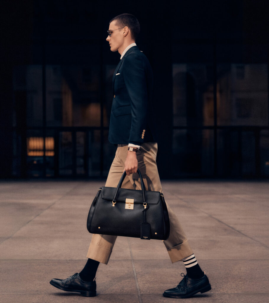 A lifestyle image of a model carrying the new Thom Browne Bolton Bag