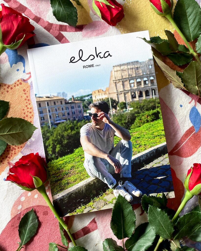 the new issue of elska with a man sitting wearing sunglasses on the cover with green grass and Colosseum in the background