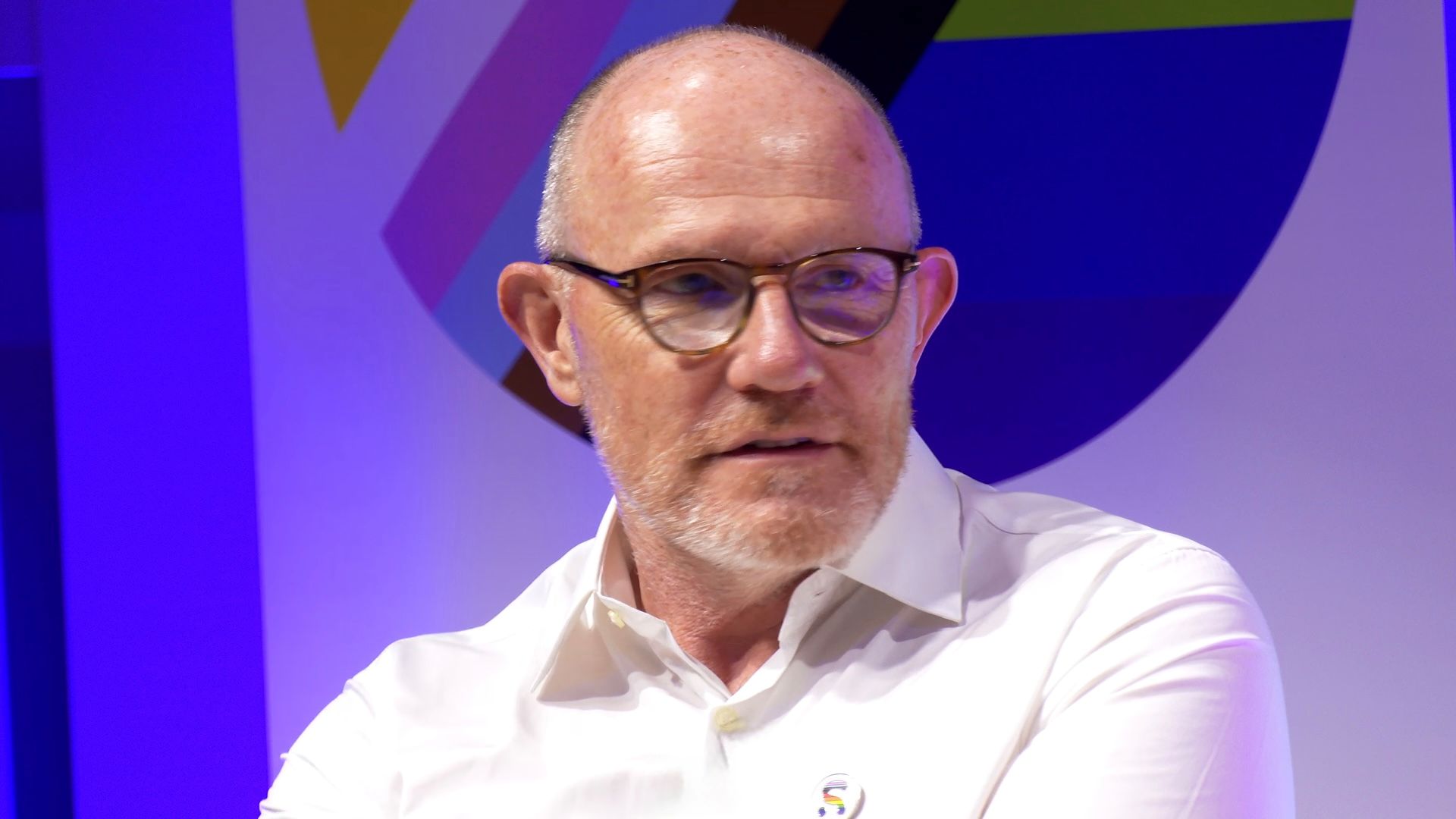 A close up of a man wearing a shirt shirt and brown glasses