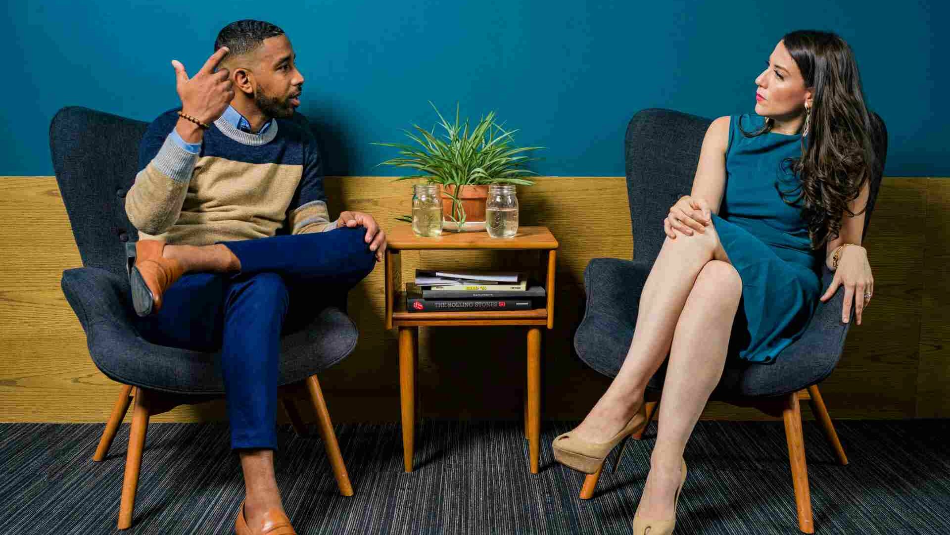 Stock image of two people sitting at a desk talking