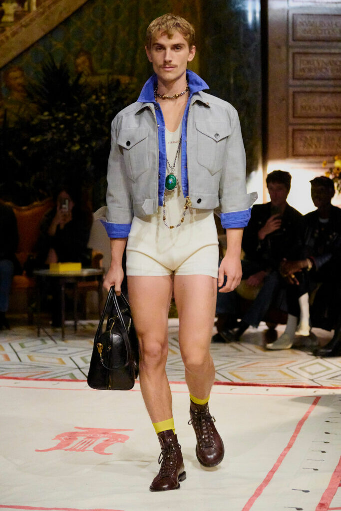 A model wears tight cycling shorts and a denim jacket from Versace Spring/Summer 2026.