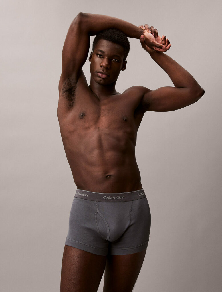 A model wears a pair of the Calvin Klein Low Rise Trunks men's underwear in grey.