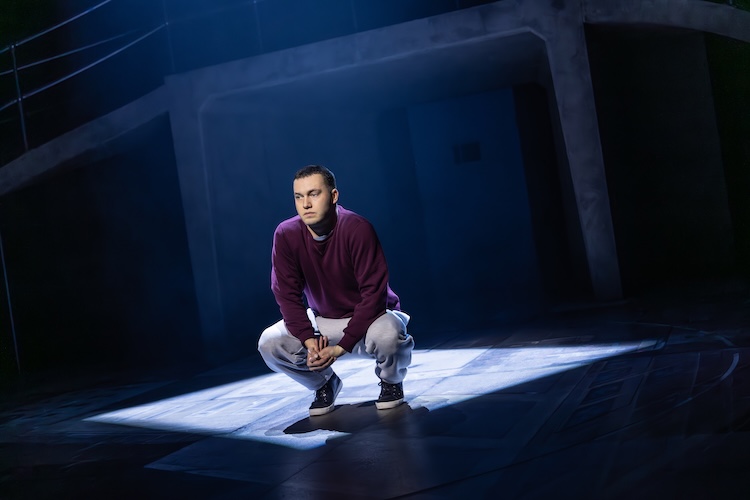 Man on stage lit by a spotlight
