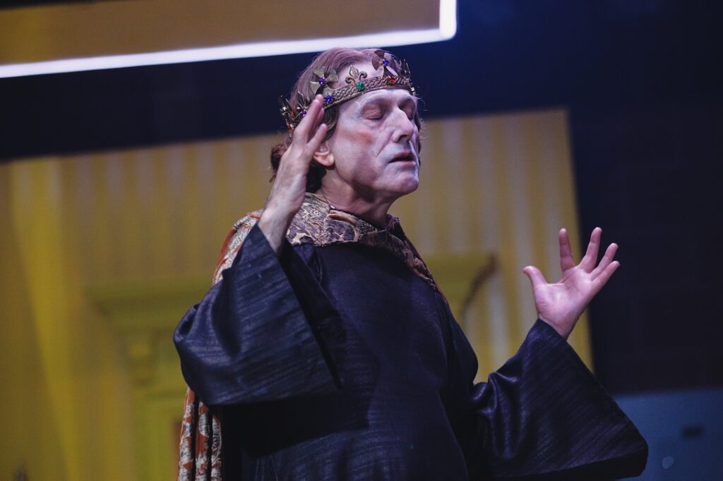 David Greenspan as Edward II raising his hands