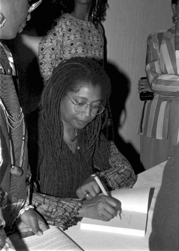 Alice Walker signing books, sat down, black and white shot