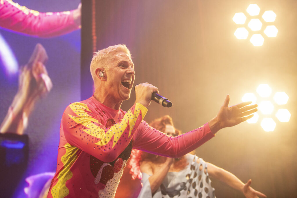 Jake Shears of the Scissor Sisters performing at last night's Attitude Awards, in a pink and yellow bodysuit with bright lights behind him