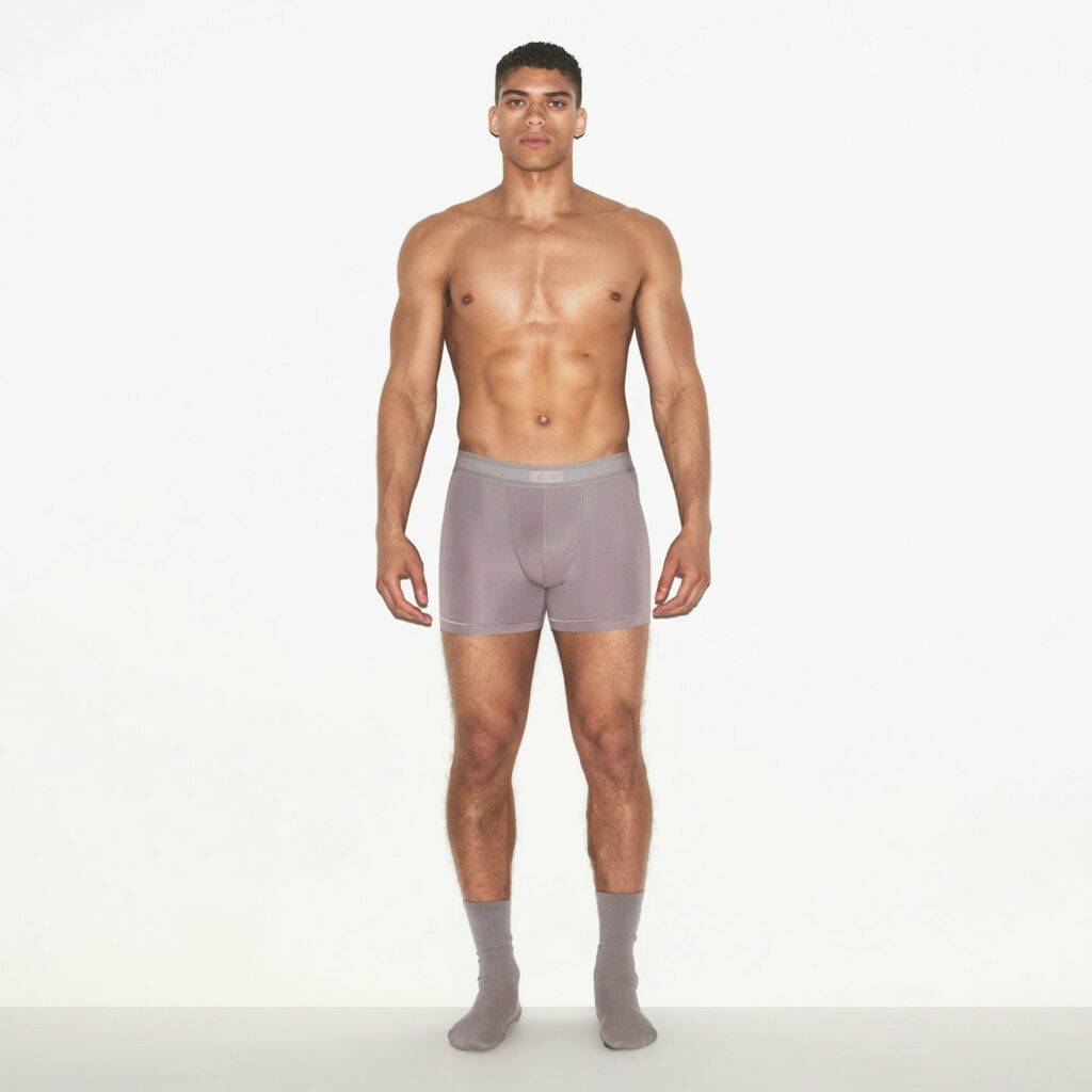 Photo of a model wearing the SKIMS 3" Boxer Brief underwear in the mauve colour Zinc.