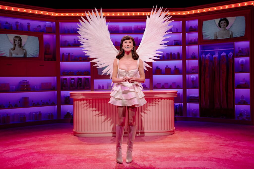 Dylan Mulvaney wearing wings on a pink stage