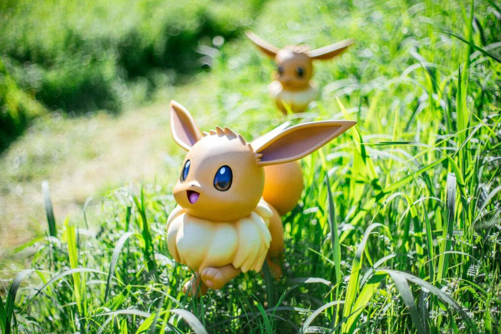 A Pokemon statue sitting among green grass