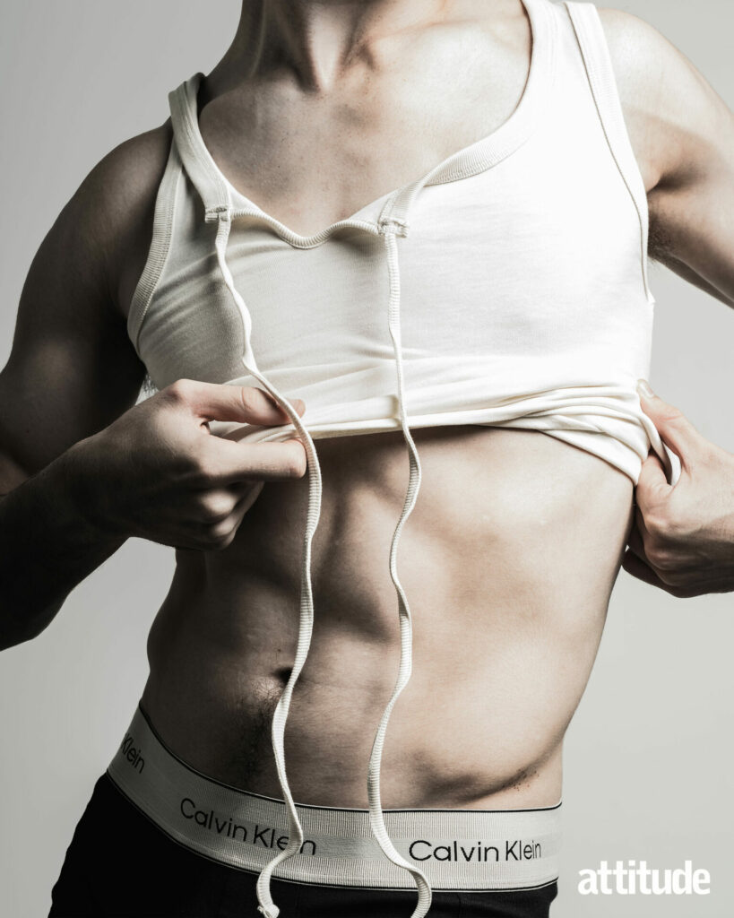 A model wearing black Calvin Klein underwear puts on a white S.S. Daley vest.