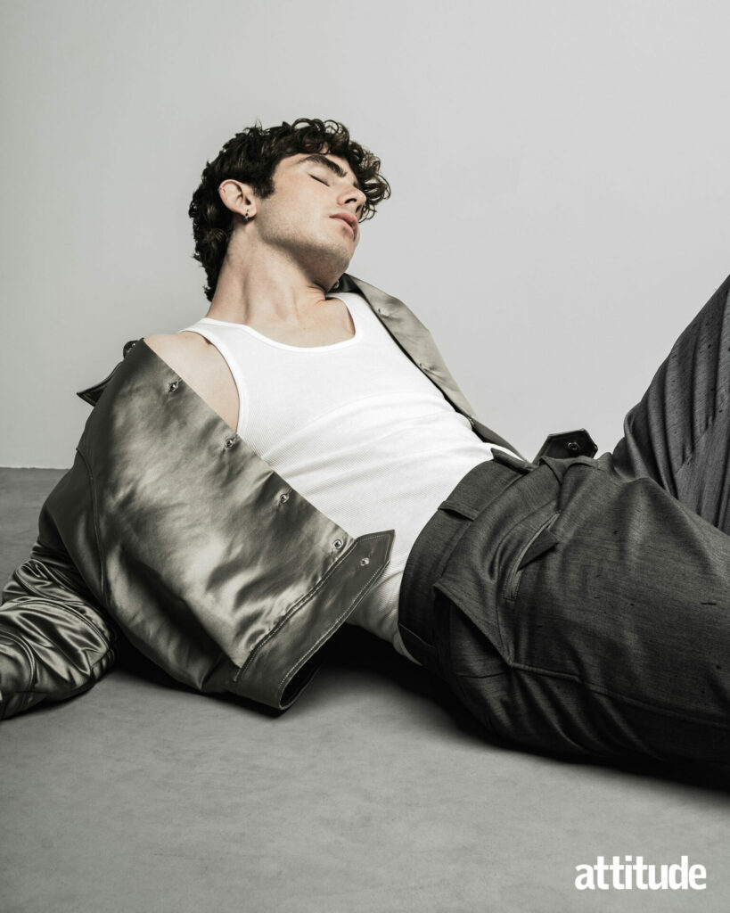 Model Edgar reclines on the ground wearing a gunmetal silver jacket from Denzilpatrick.