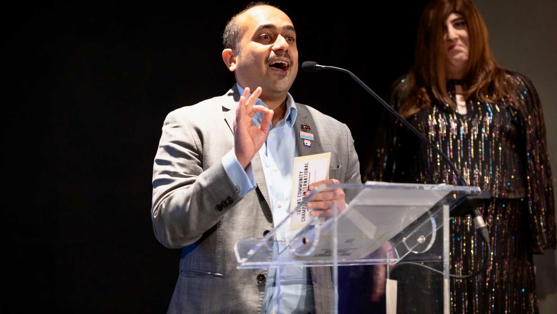 A man giving a speech on stage at an awards ceremony