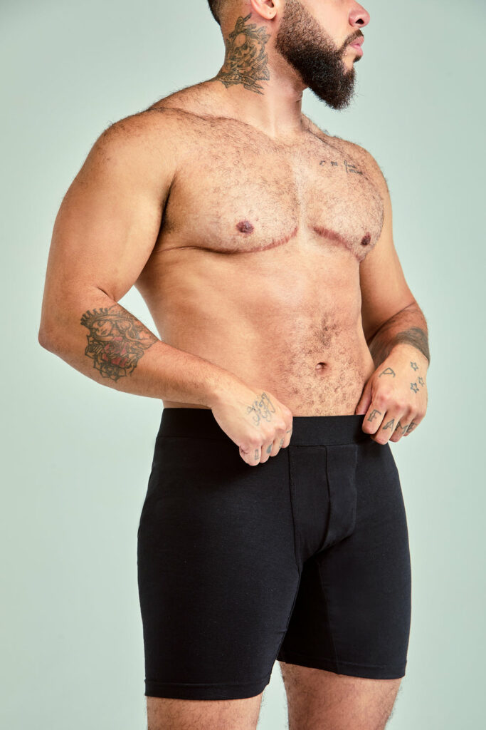 A transgender male model wears the LostFrame Alex in black.