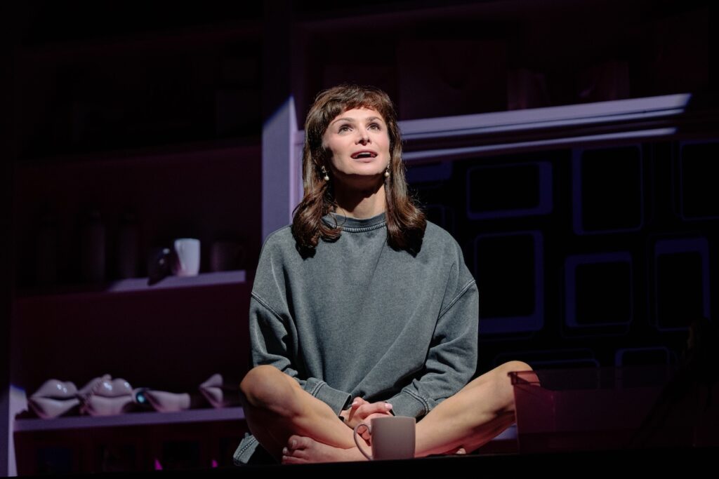 Dylan Mulvaney on stage wearing a grey jumper