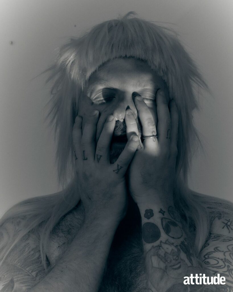 Ginny Lemon with their hands on their face with closed eyes