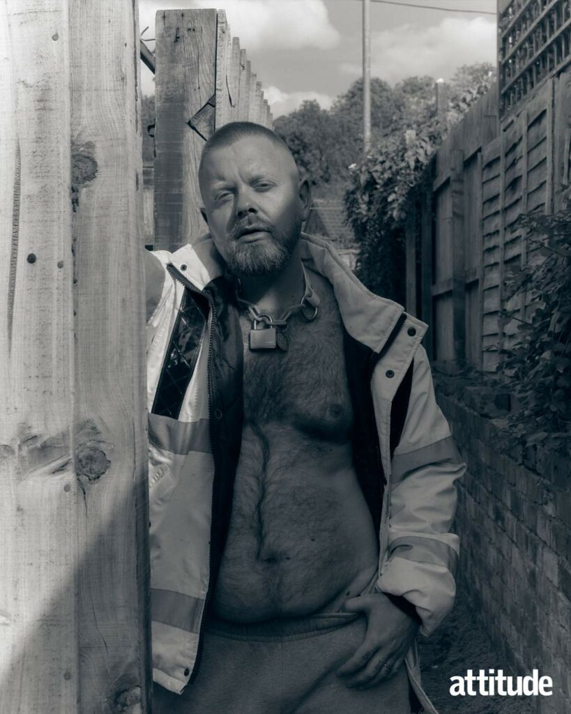Ginny Lemon wearing a high-vis jacket and a padlock necklace