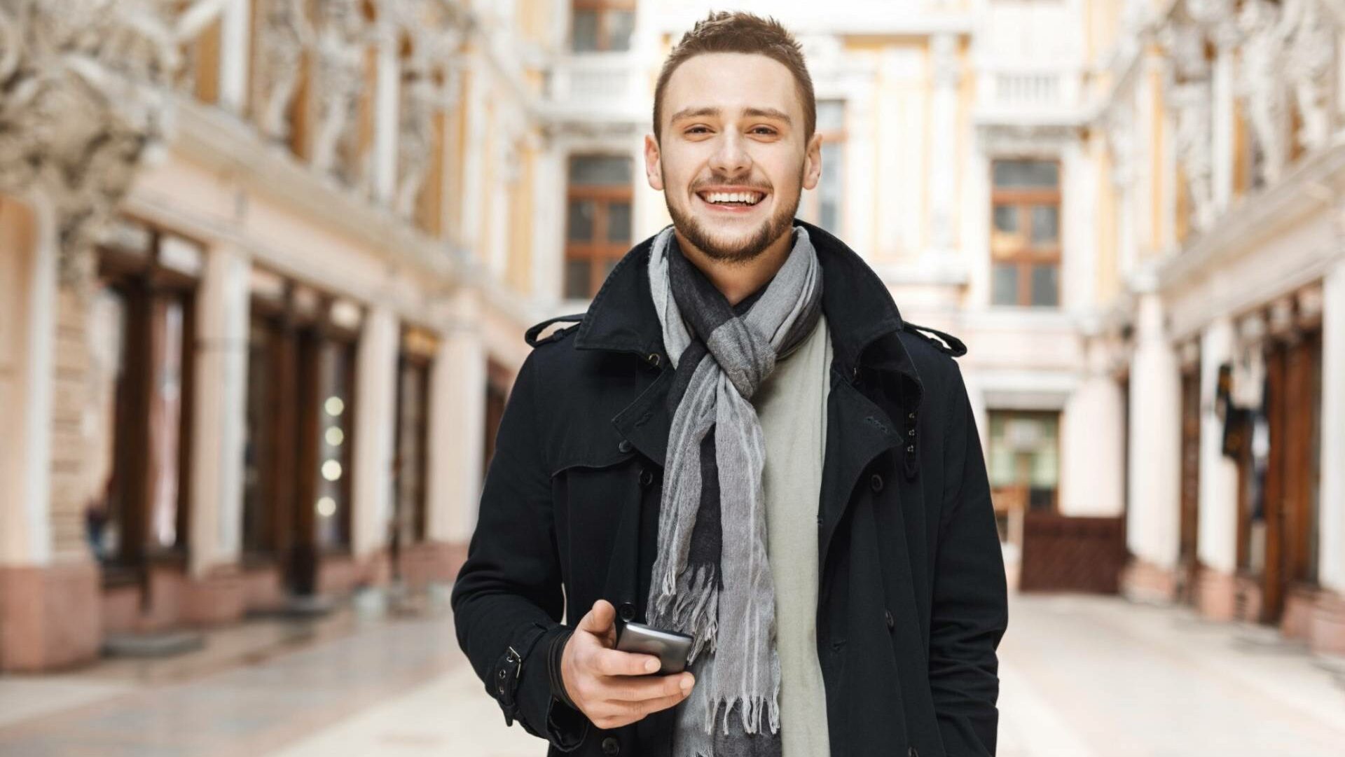Smiling man holding a phone