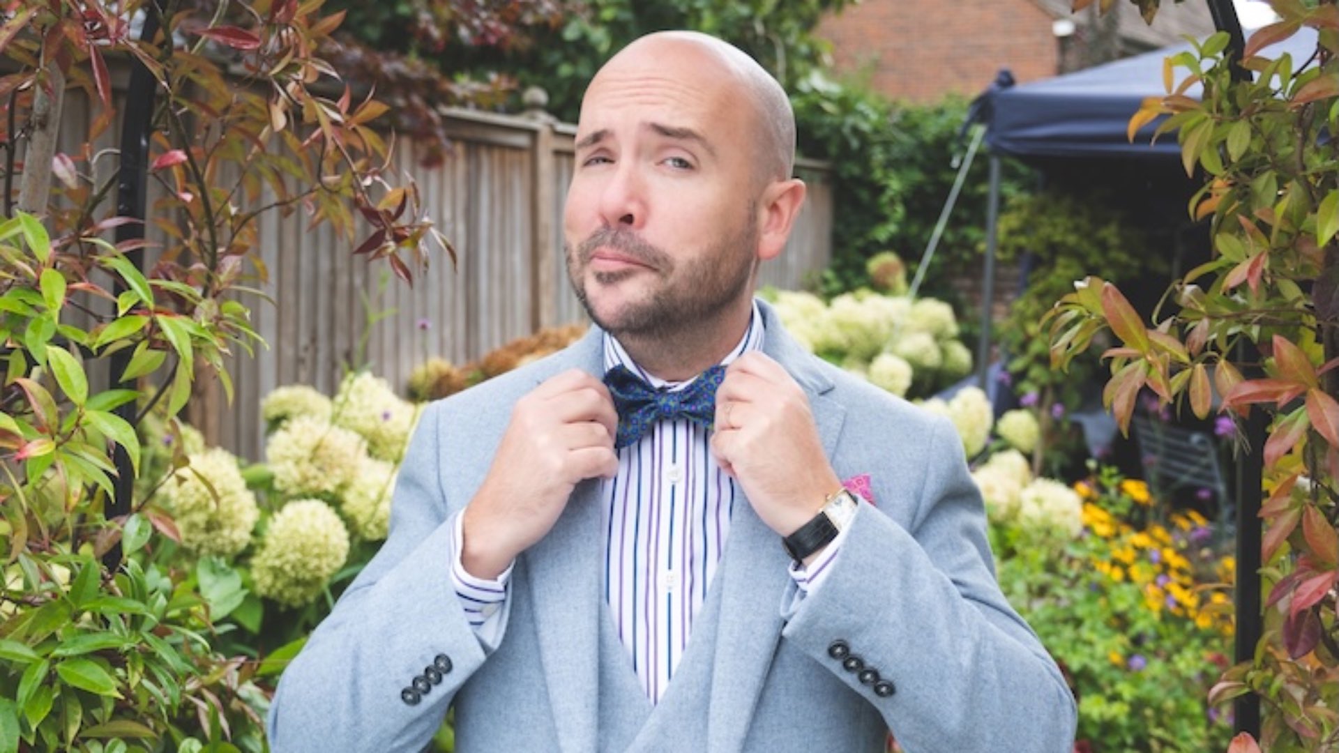 Tom Allen in a blue suit and bow tie in the garden