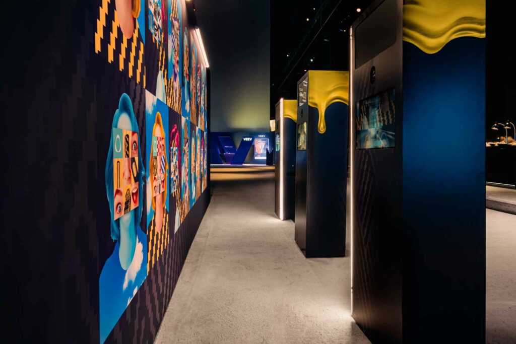 A Seletti exhibition corridor with illuminated artwork and blue and yellow design panels