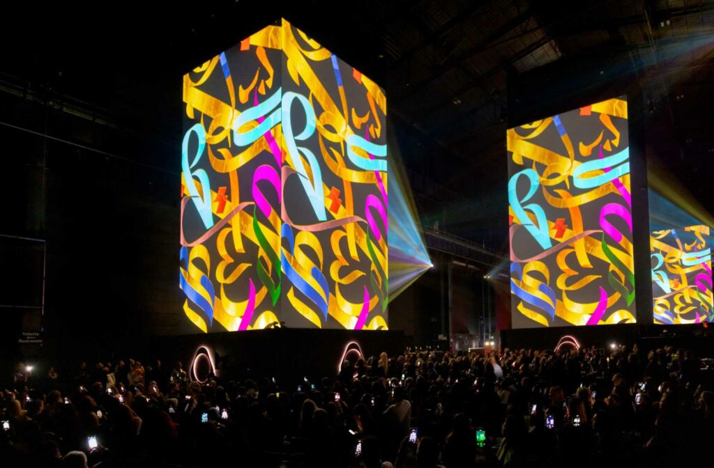 Large geometric projections in colourful patterns before a crowd