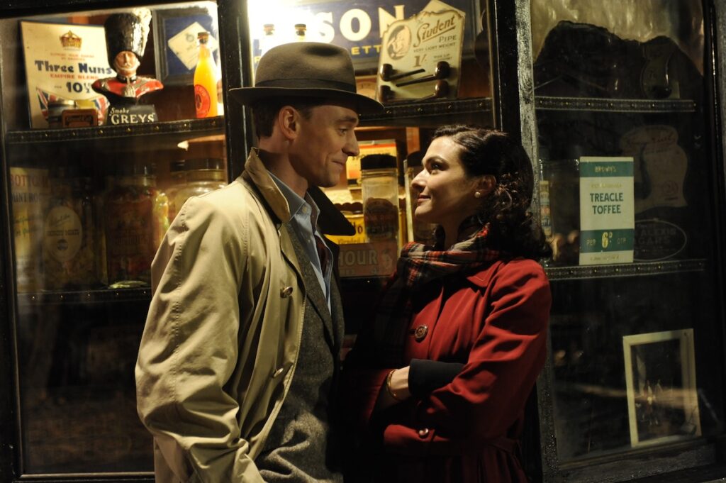 a still from The Deep Blue Sea, a man and a woman in coats talking outside a shop