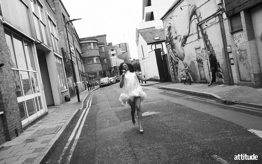Tiara Skye in a white sequin high neck dress with a feather bottom running through the streets in black and white