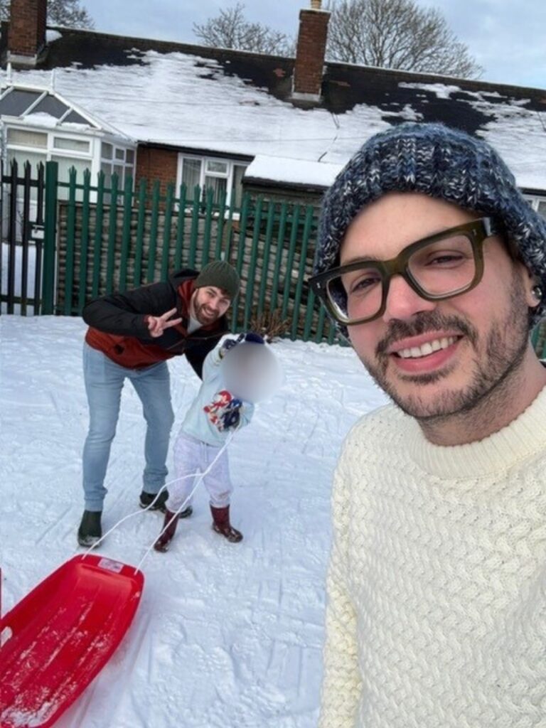 the dads with their son pulling a sledge in the snow