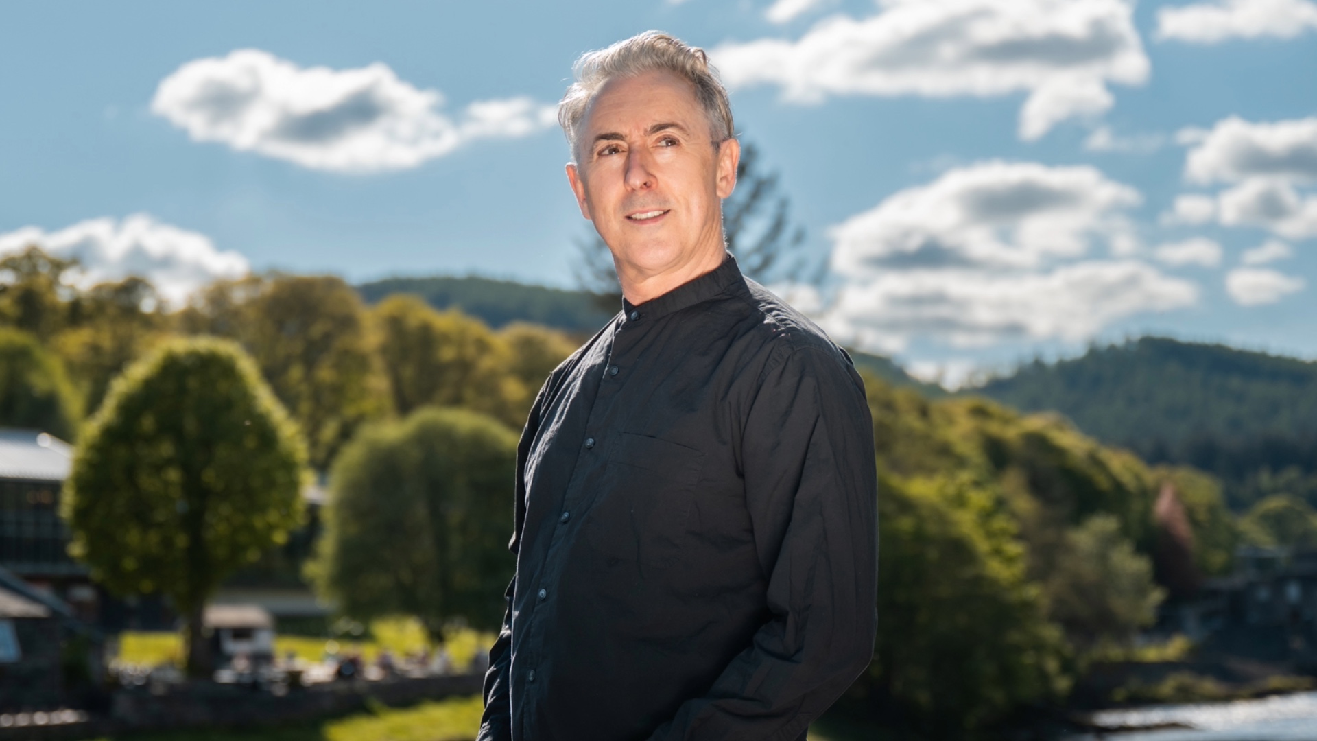 Alan Cumming against a landscape backdrop