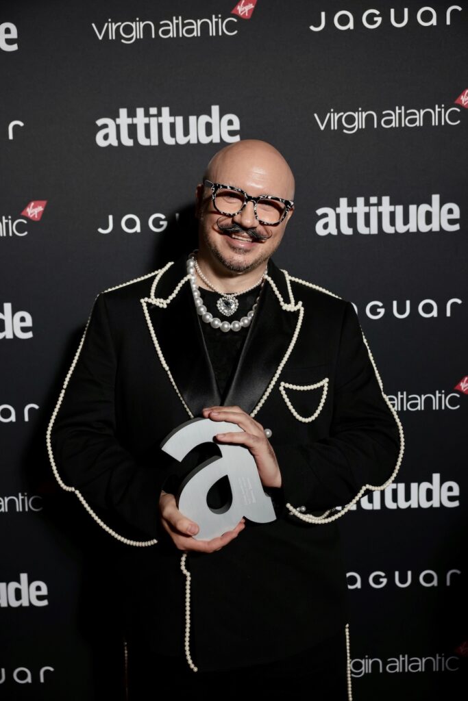 Dominic Skinner in black suiting holding award