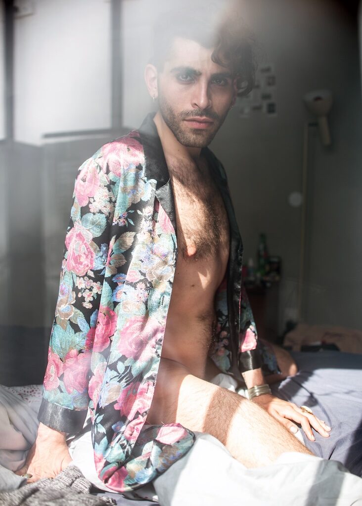 Gregory C, in a floral jacket undone with bare chest shoring, curly dark hair (Image: Elska/Liam Campbell)