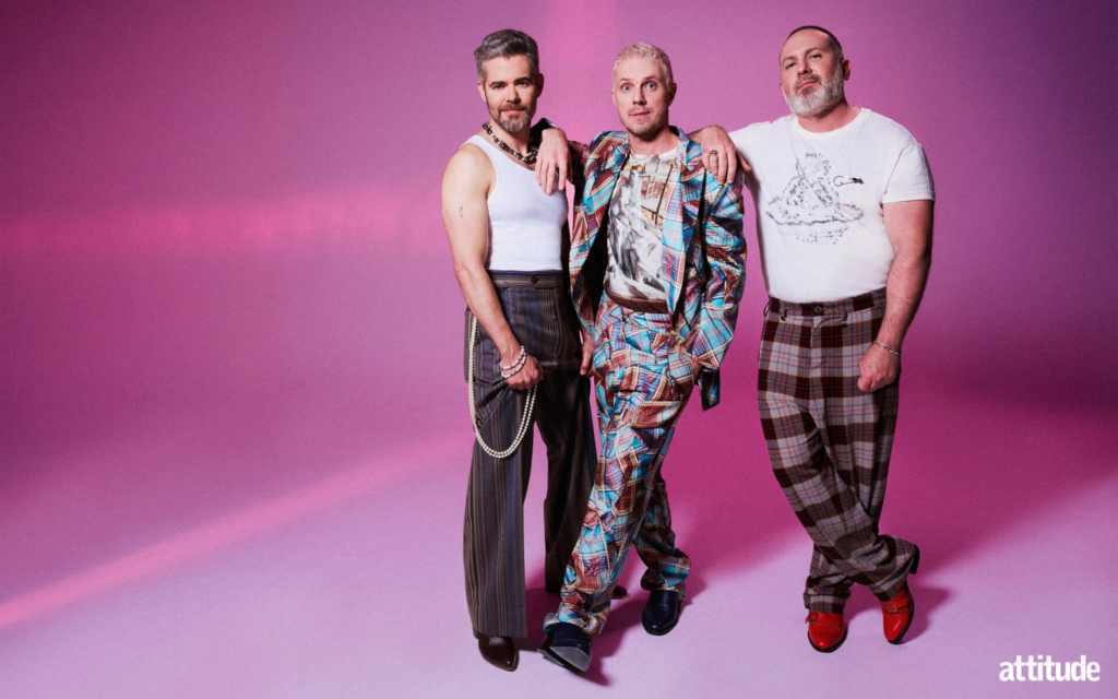 The members of Scissor Sisters wearing Vivienne Westwood outfits standing against a pink backdrop