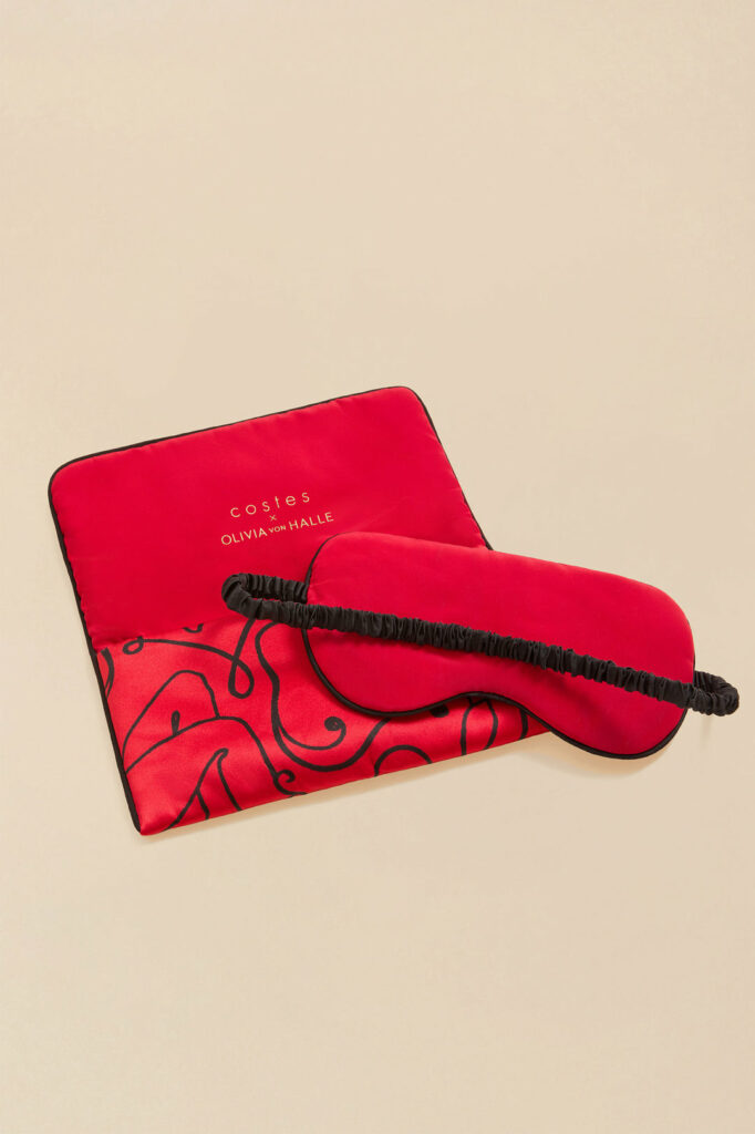 A lifestyle shot of the red silk Audrey Costes Eye mask.