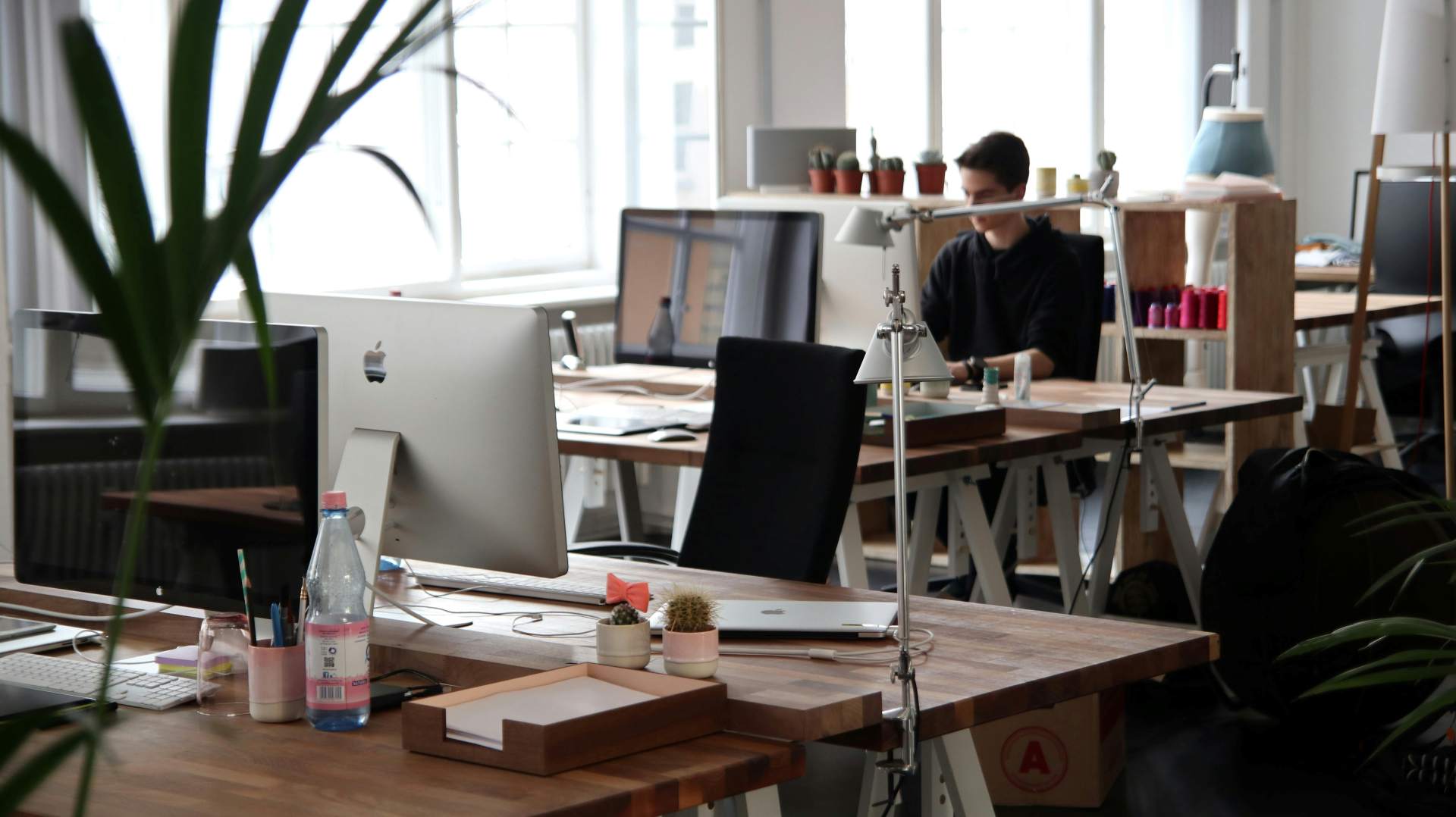 Interior of an office building showing desks and a man sitting at a desk