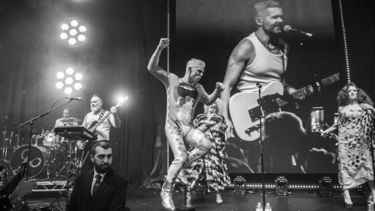 Scissor Sisters performing at last night's Attitude Awards, black and white, Jake leaping and a nonplussed security guard in the front (Image: Attitude/Aaron Parsons)